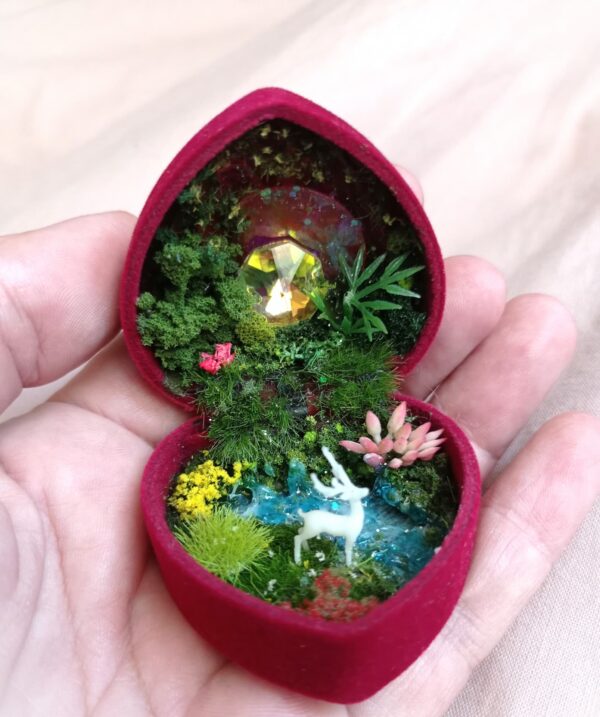 Écrin forme cœur contenant un paysage féerique.